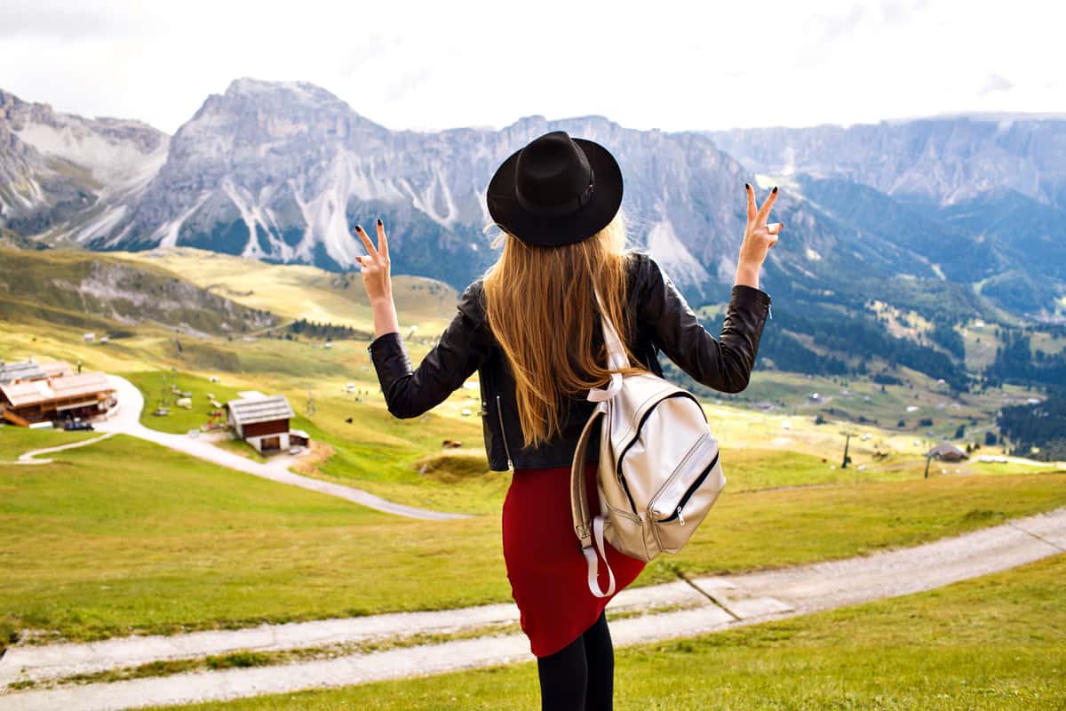 Ragazza con lo zaino davanti a un panorama di montagna