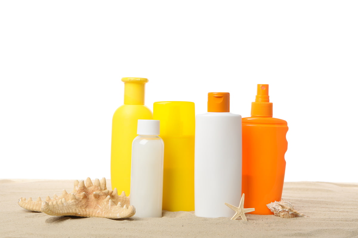 Confezioni di crema solare posizionate sulla sabbia