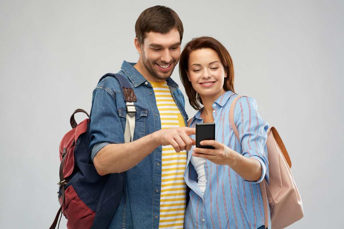 Due persone con zaini che guardano smartphone