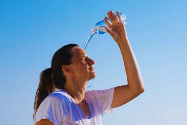 Ragazza che si rinfresca versandosi dell'acqua addosso