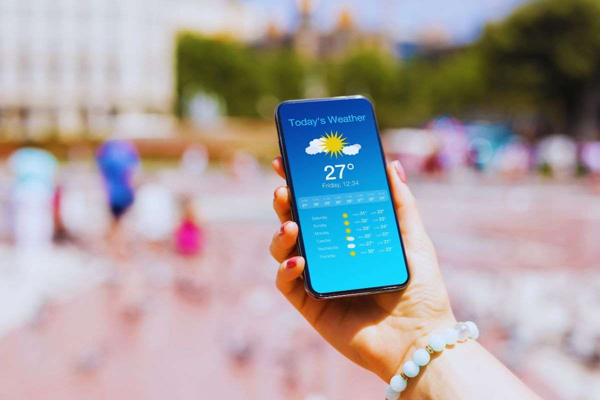 Donna che guarda previsioni meteo in spiaggia