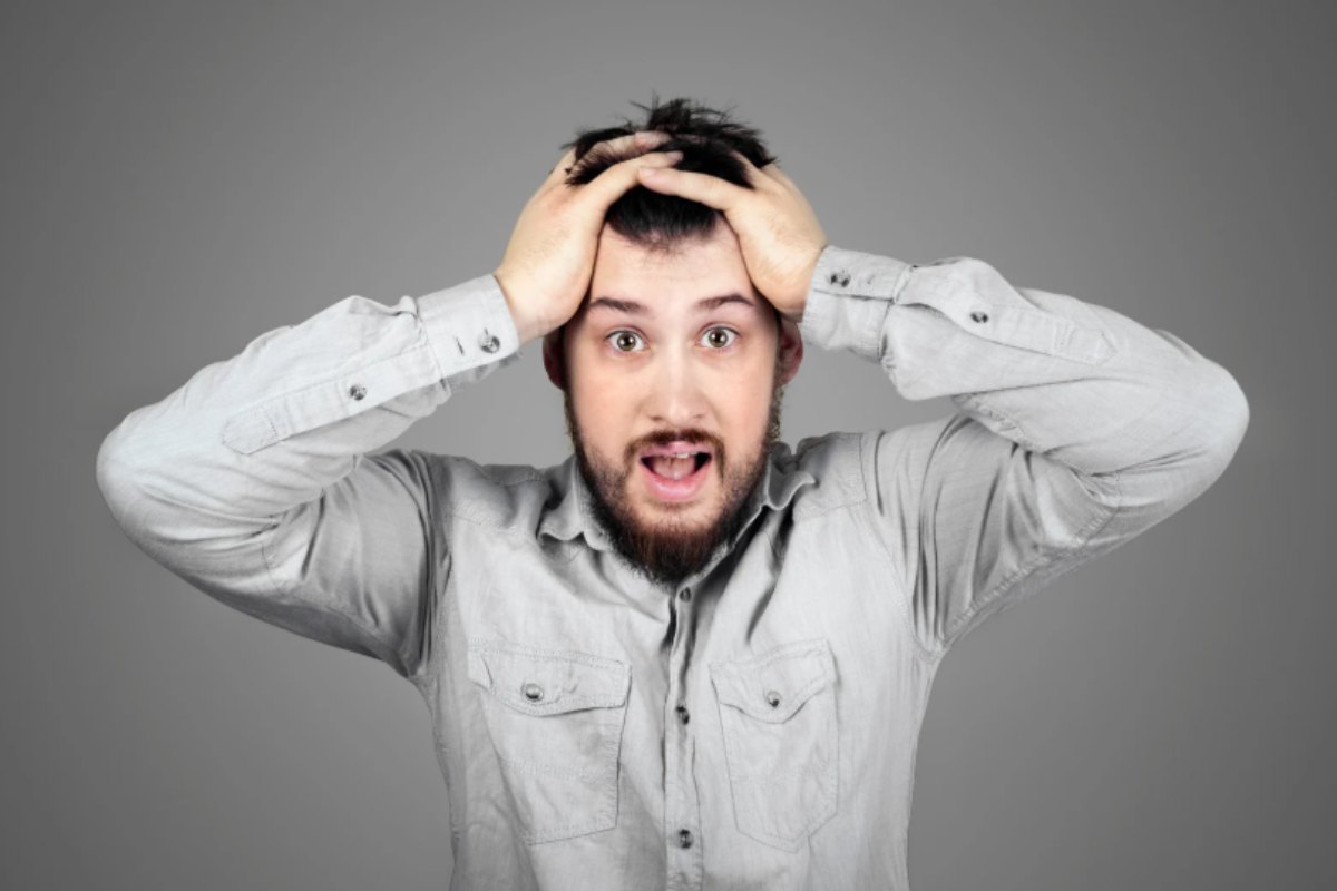 uomo disperato con le mani nei capelli