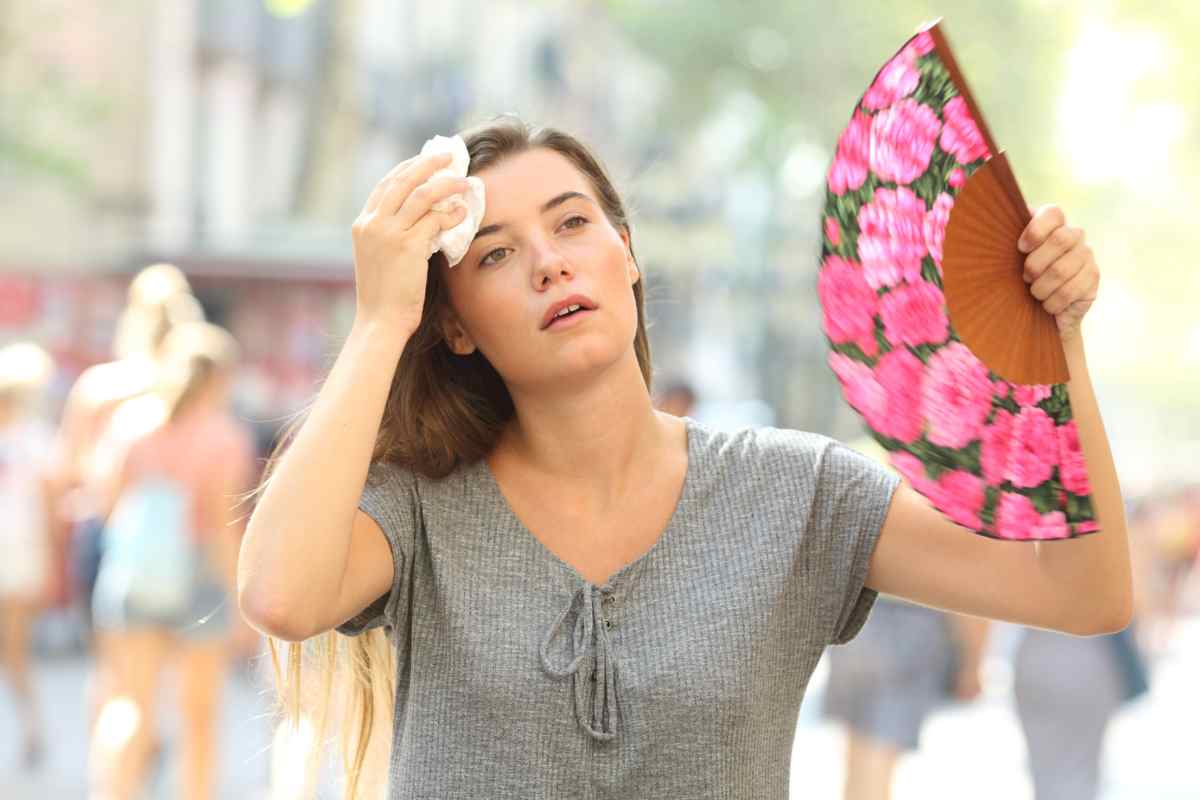 Donna accaldata con ventaglio a fiori