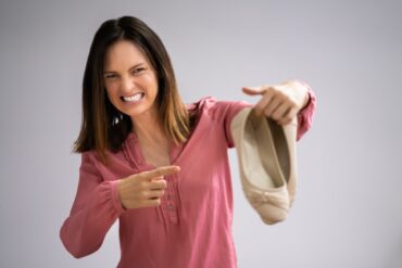 donna con scarpe maleodoranti in mano