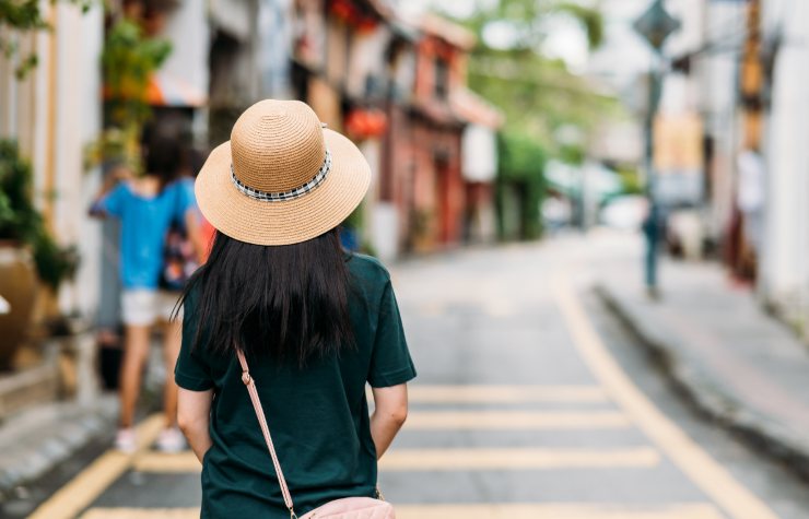turista di spalle donna con cappello in città