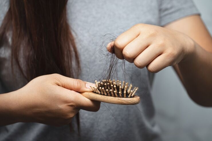 Ragazza stacca capelli dalla spazzola