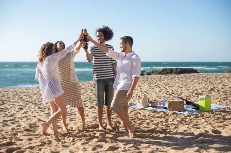 ragazzi contenti in spiaggia battono il cinque