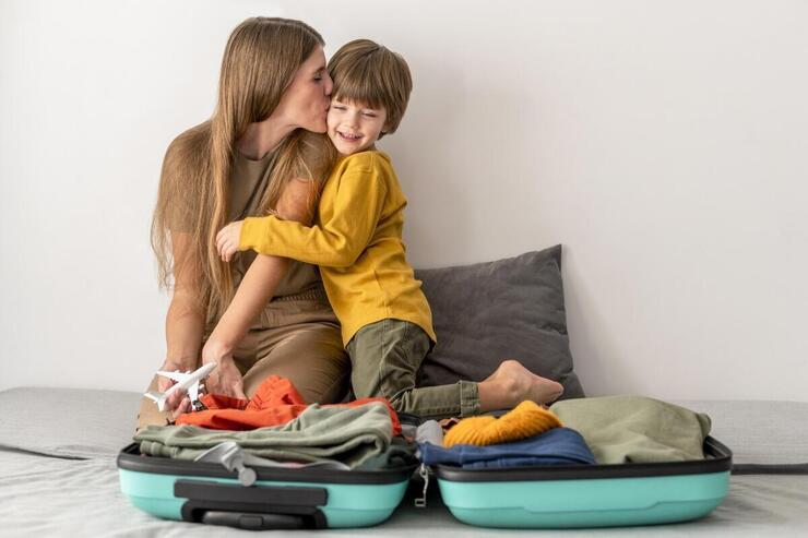 Mamma e bambino davanti a una valigia aperta