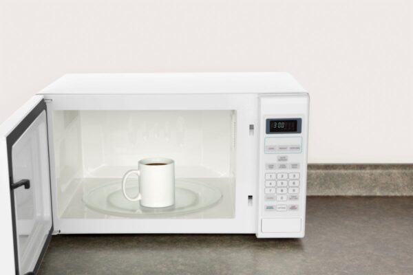 Tazza bianca con liquido scuro nel microonde