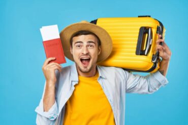 uomo felice con una valigia sulle spalle e il passaporto in mano