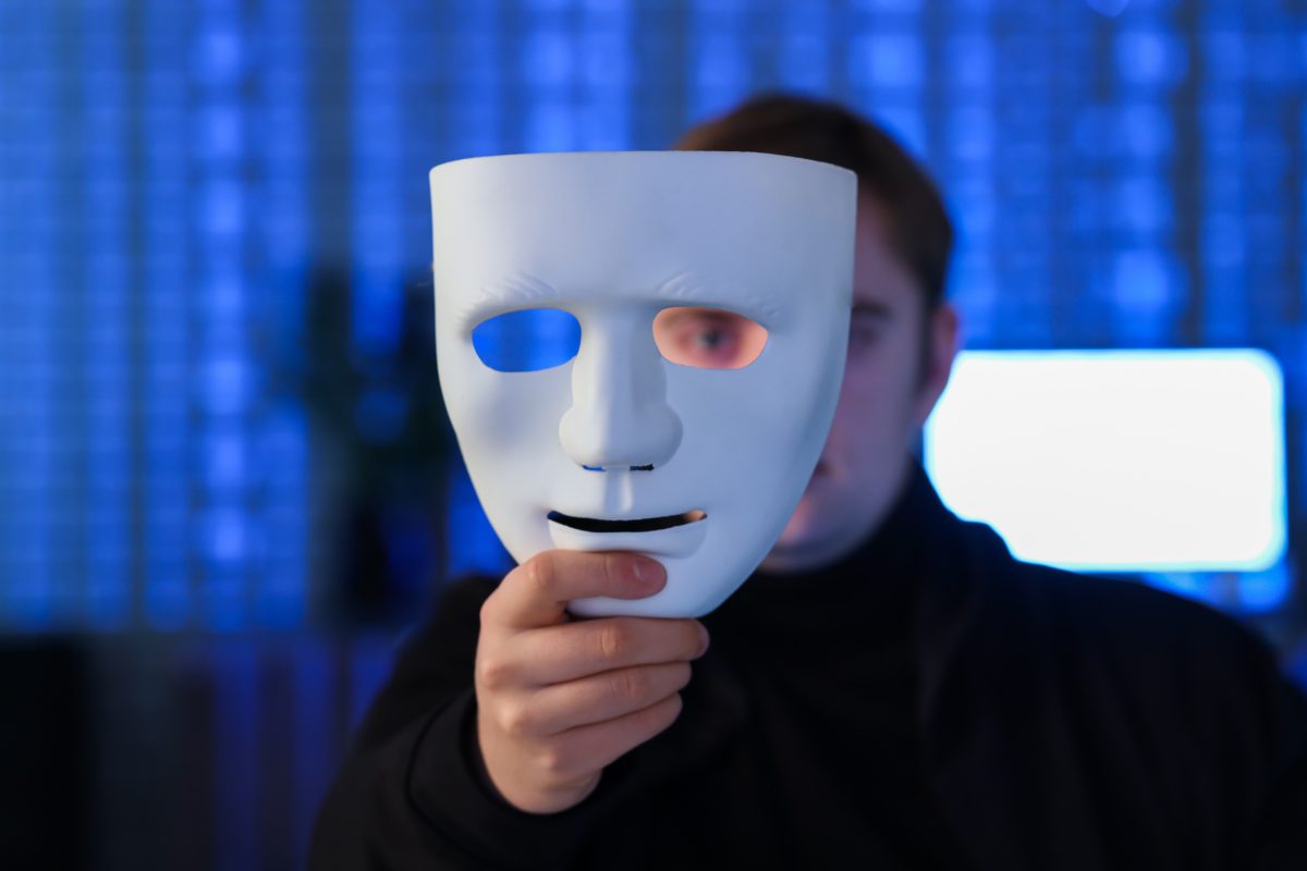 Uomo che copre la faccia con una maschera