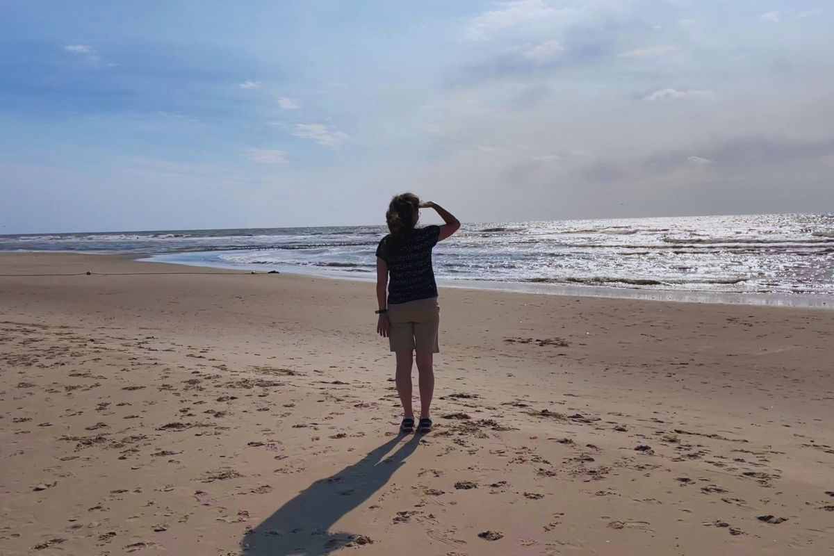 Ragazza che osserva il mare in una giornata nuvolosa 