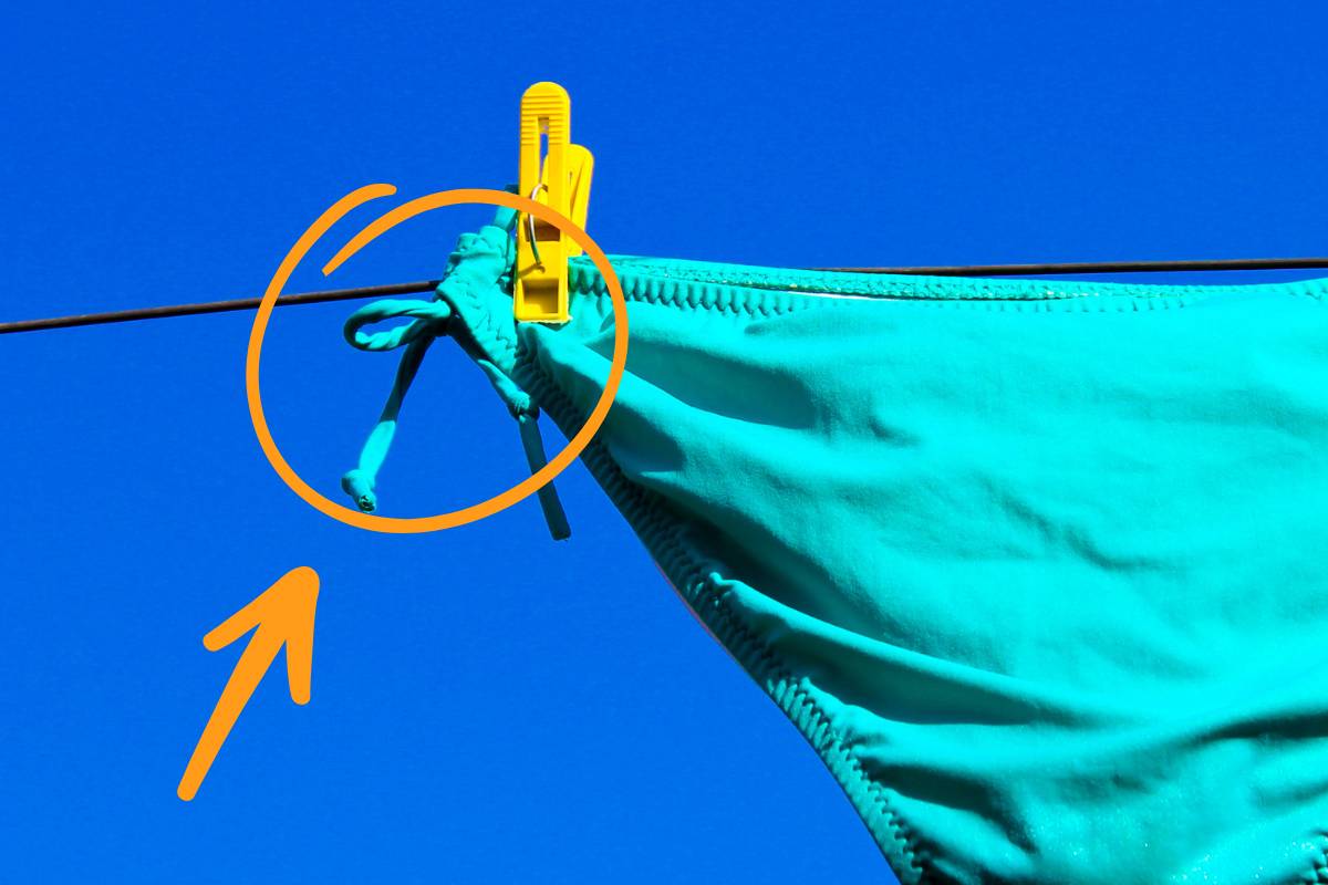 Parte inferiore di un costume da donna steso e freccia che indica i laccetti