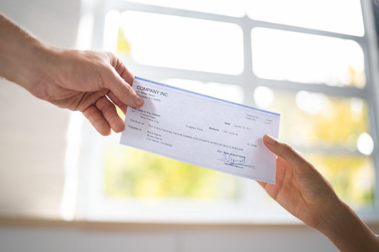 Persone si scambiano un assegno