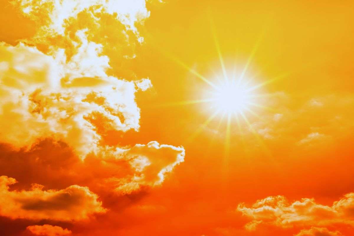 Sole che splende in un cielo arancione