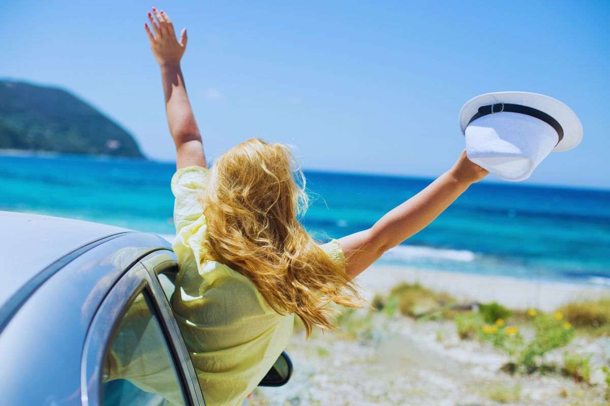 Donna si affaccia dal finestrino per "salutare" la spiaggia