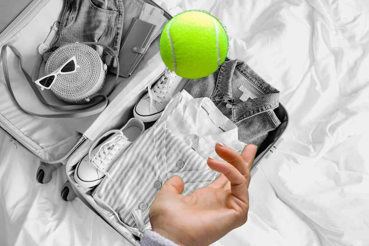 Valigia e pallina da tennis