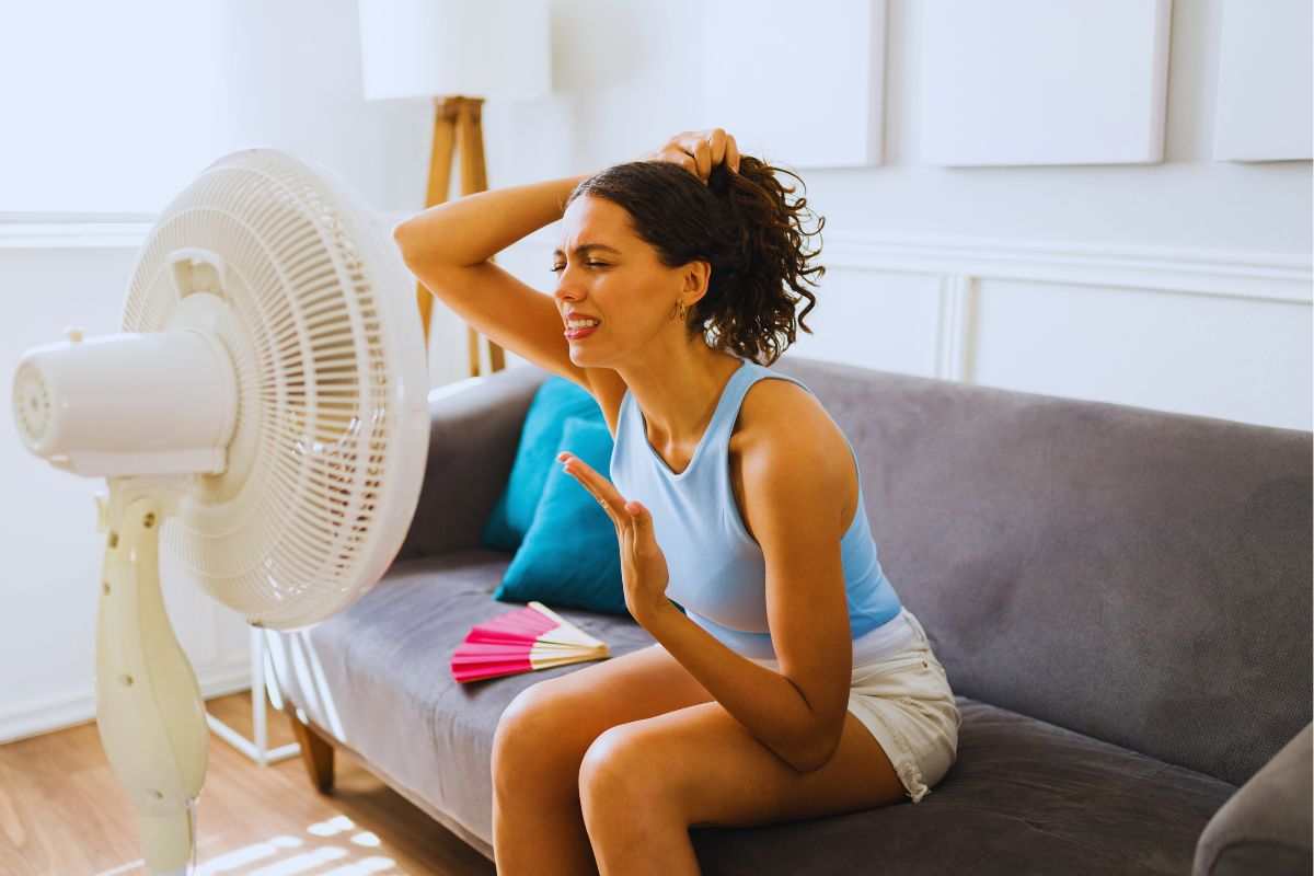 donna cerca refrigerio davanti al ventilatore