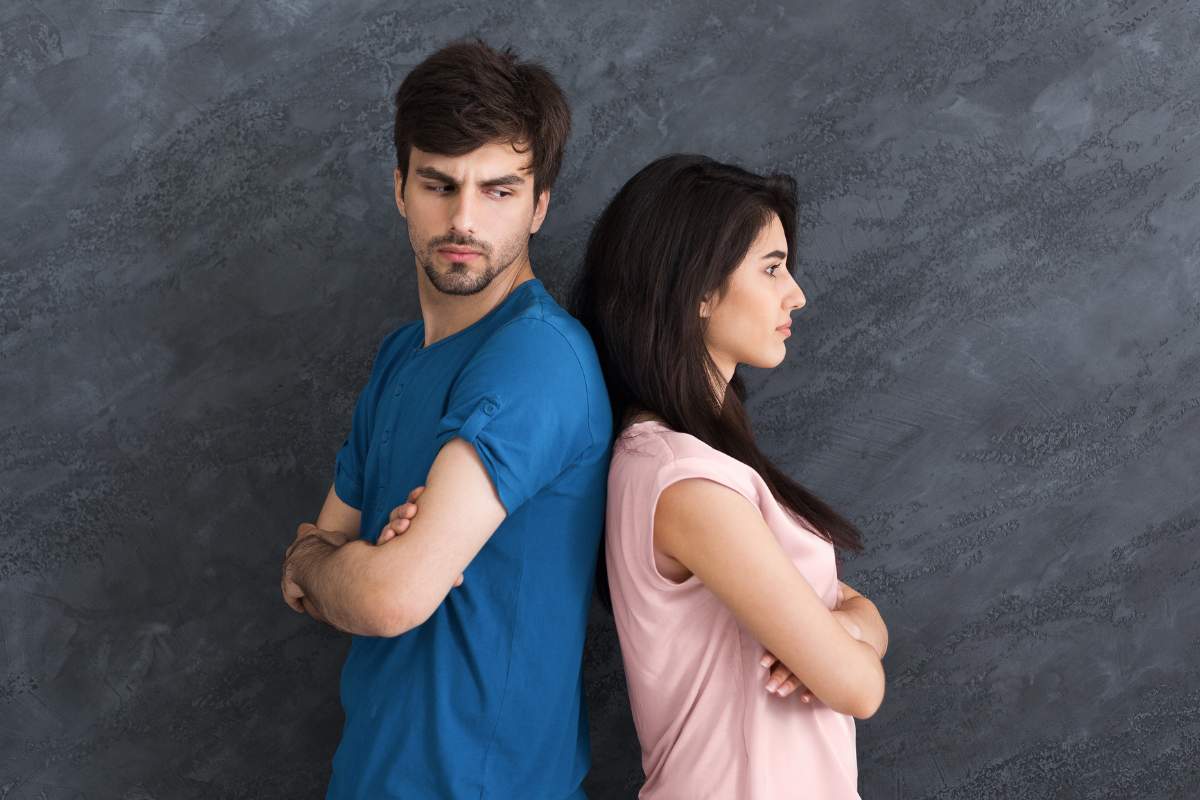 uomo e donna arrabbiati spalle contro spalle