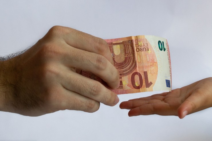 mano maschile porge banconota da 10 euro a mano femminile