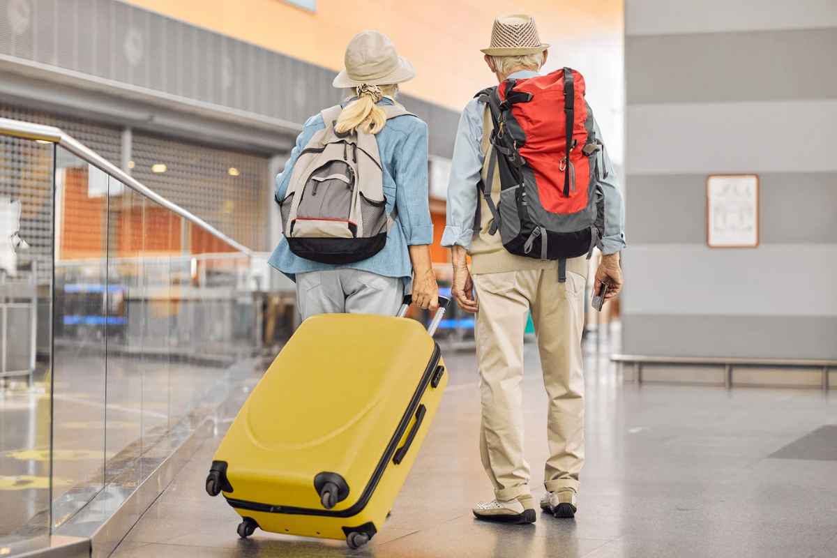 Due persone con zaini e valigia