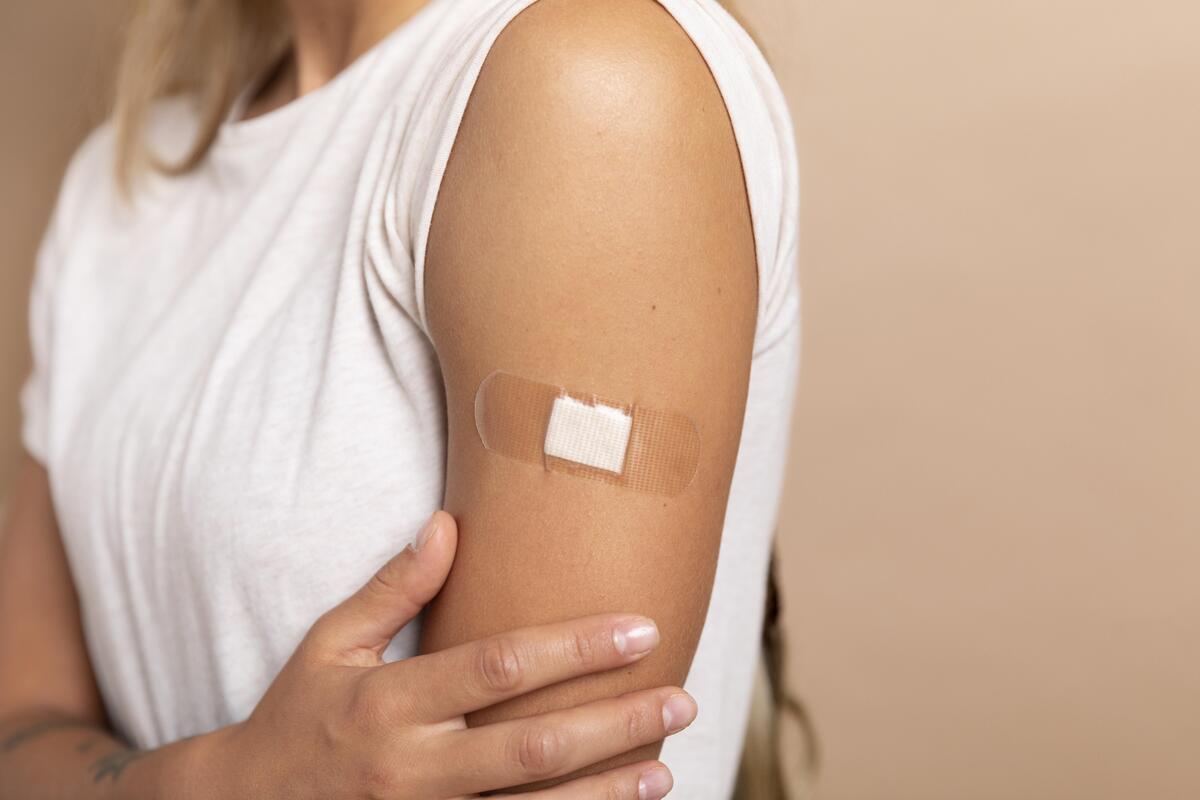 Donna che ha un cerotto sul braccio