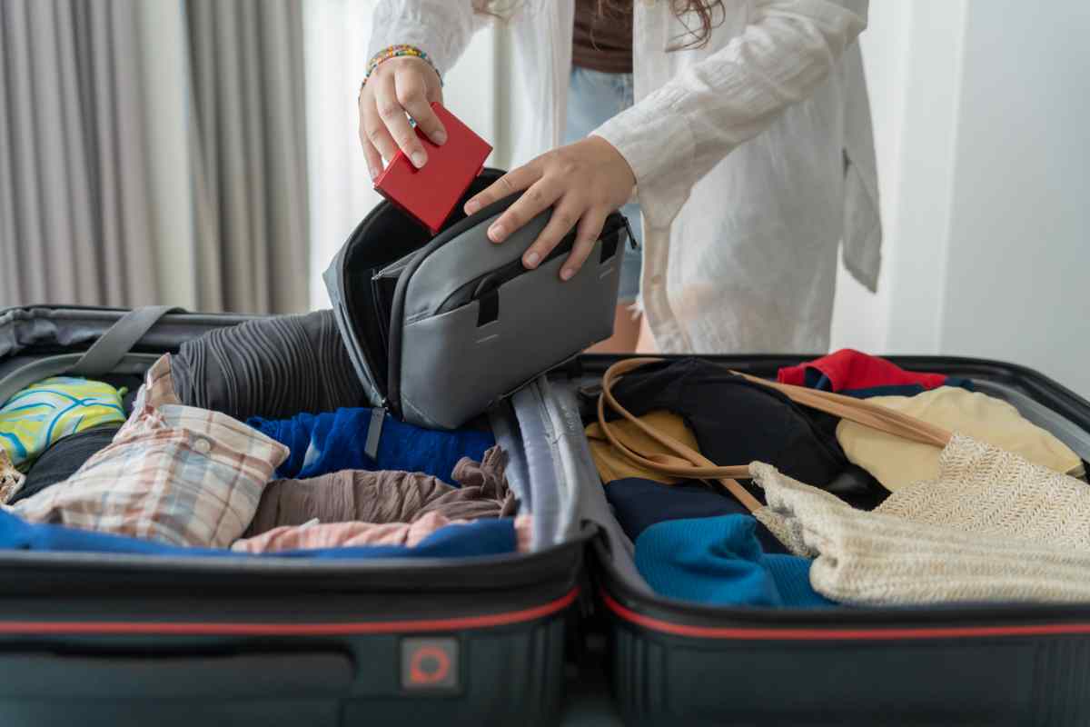 Donna con valigia aperta sul letto