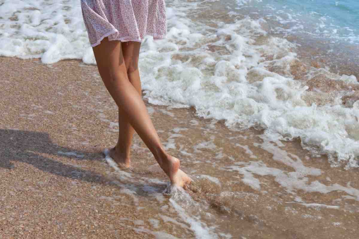 Donna che cammina sulla riva