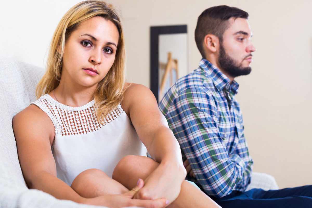 Un uomo e una donna imbronciati seduti sul divano