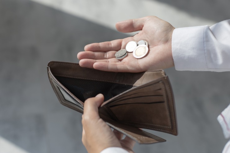 uomo con portafogli portafoglio vuoto e poche monete in mano