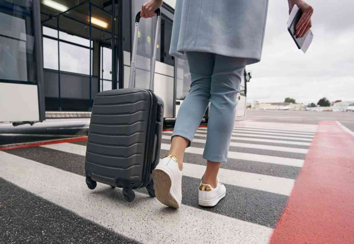 Donna che trascina trolley sulle strisce pedonali