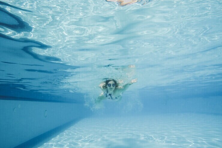 ragazza che nuota in piscina, vista subacquea