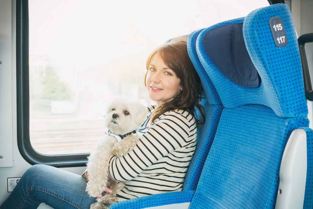 Donna su treno con cane in braccio