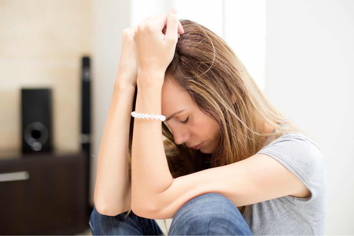 Donna inginocchiata su se stessa