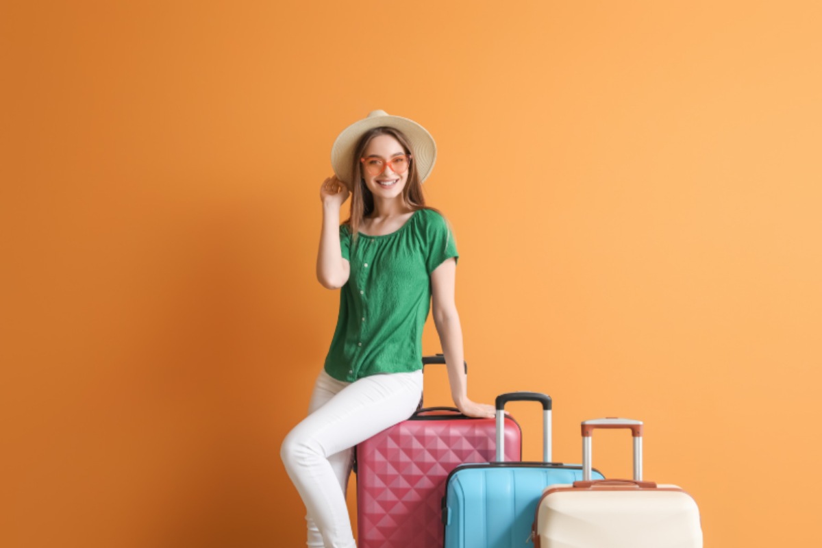 donna sorridente con tre valigie