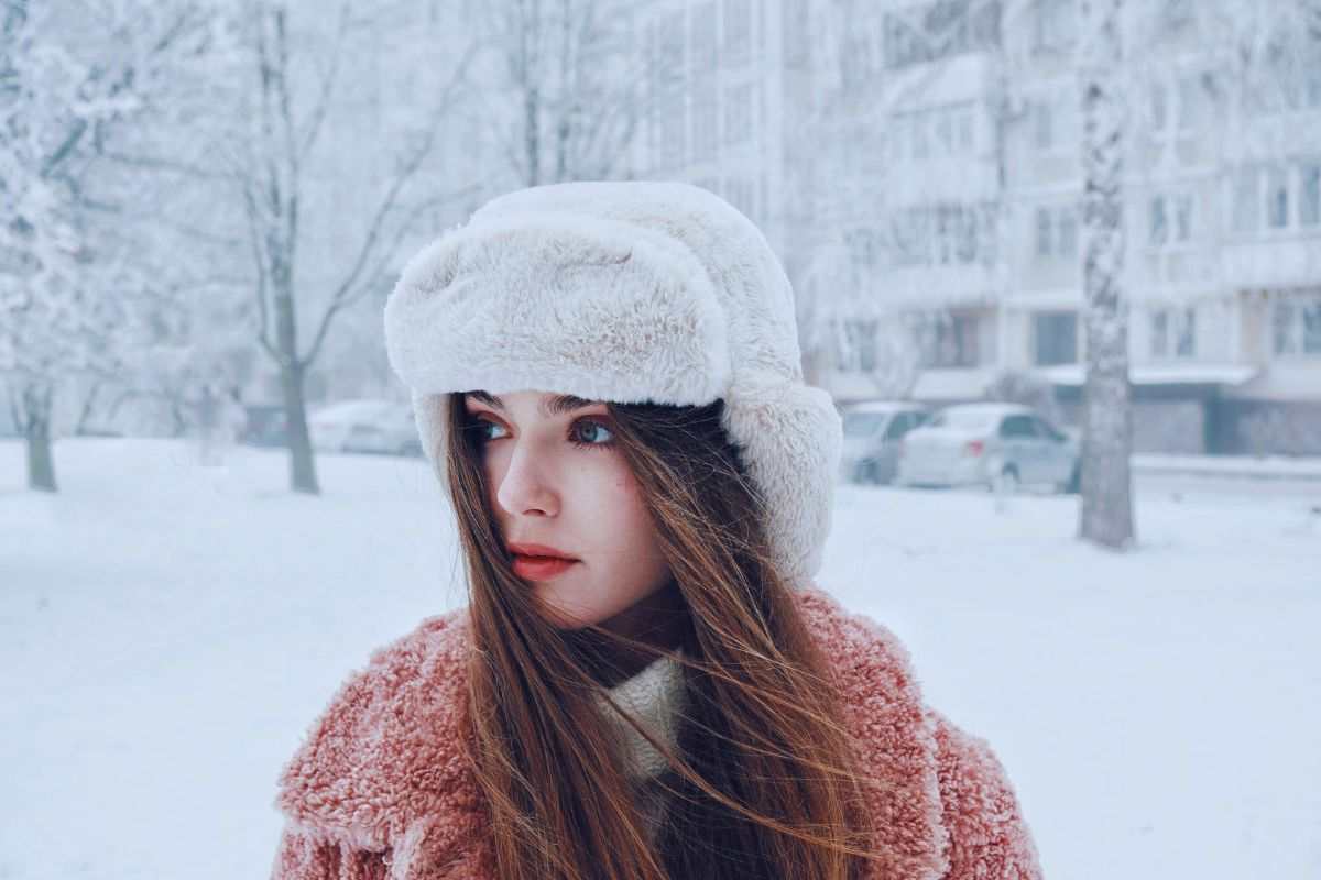 Ragazza che cammina in una strada innevata