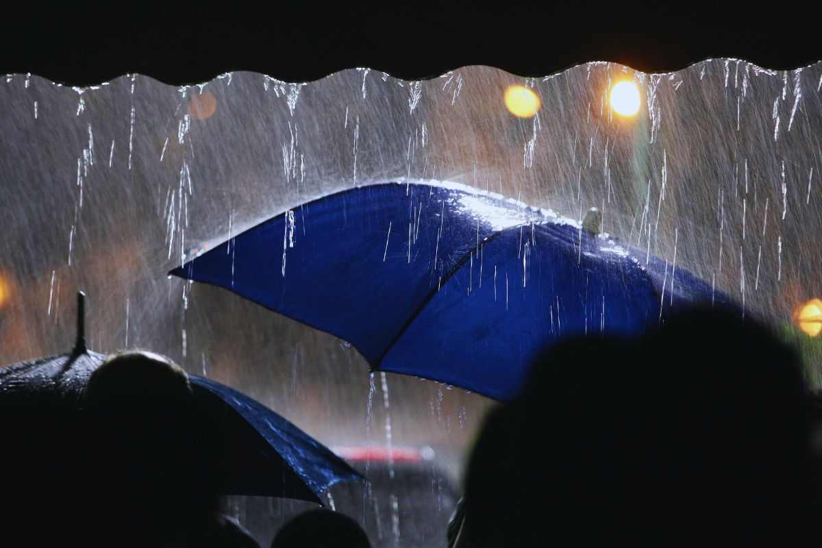 Persone che si riparano dalla pioggia sotto gli ombrelli