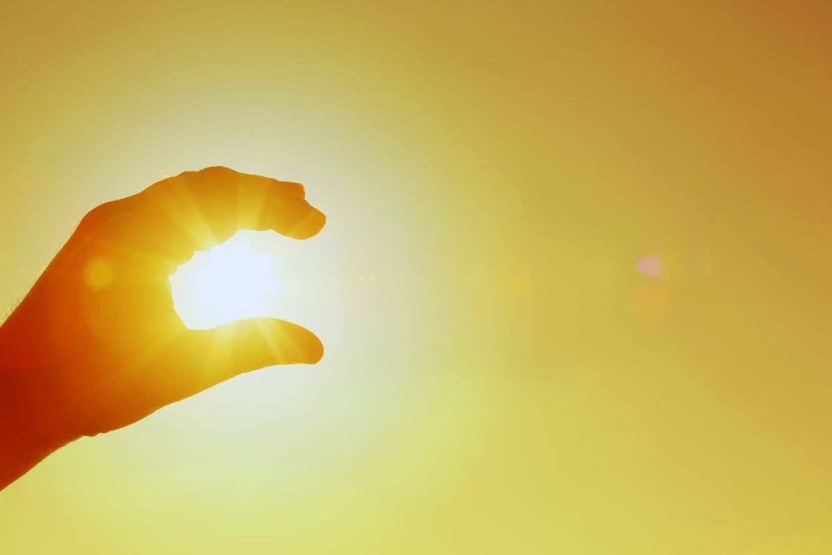 persona che circoscrive il sole all'interno della propria mano