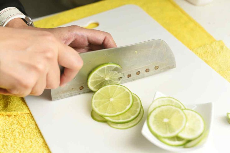 Persona che taglia limoni su tagliere