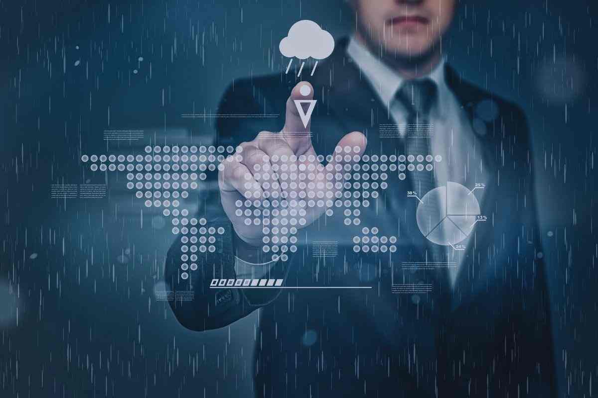 Uomo che tocca con indice l'icona di una nuvola carica di pioggia