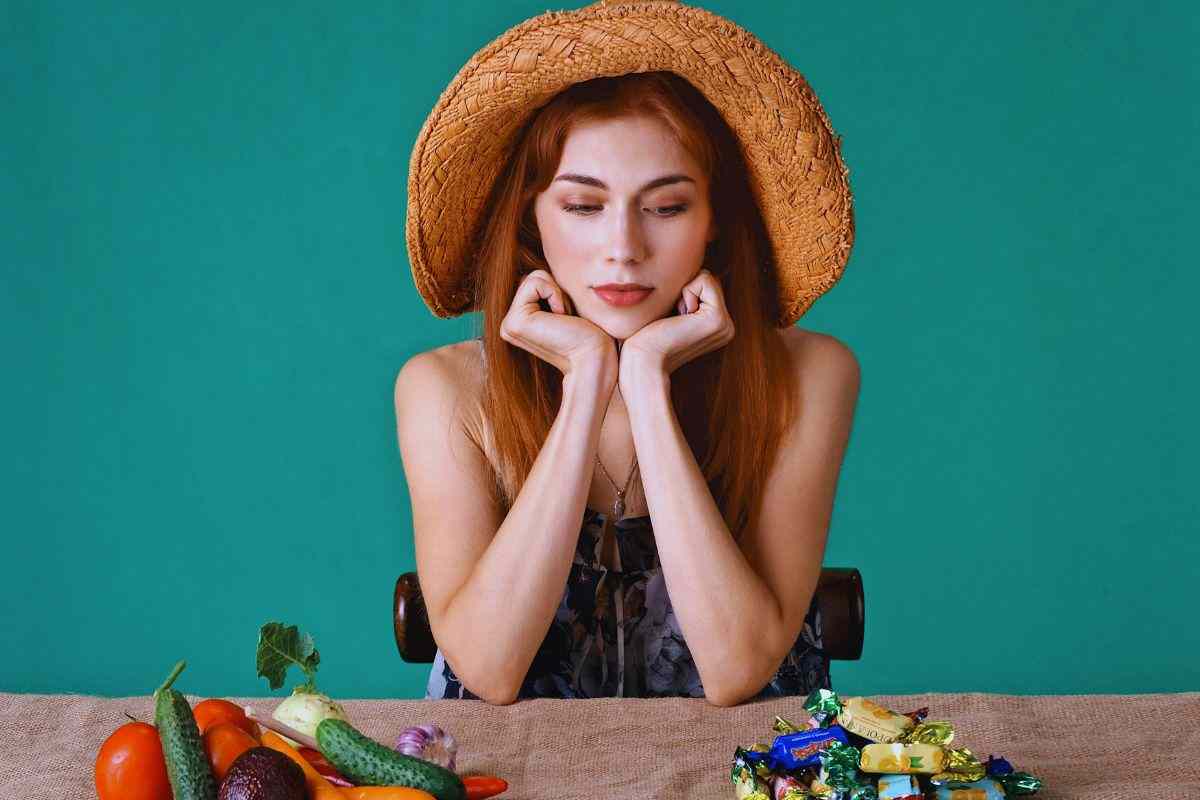 Ragazza che fissa caramelle poggiate su tavolo