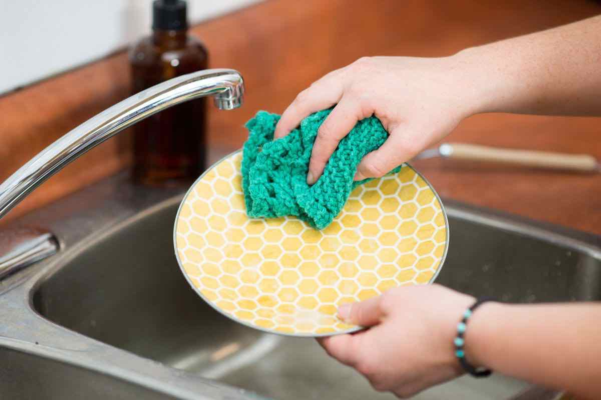 Persona che lava i piatti a mano