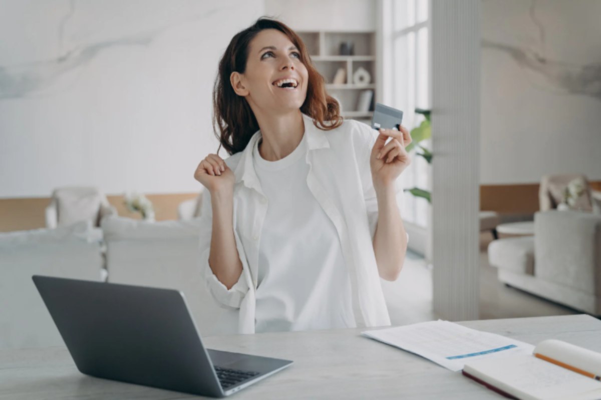 donna che esulta seduta davanti al computer