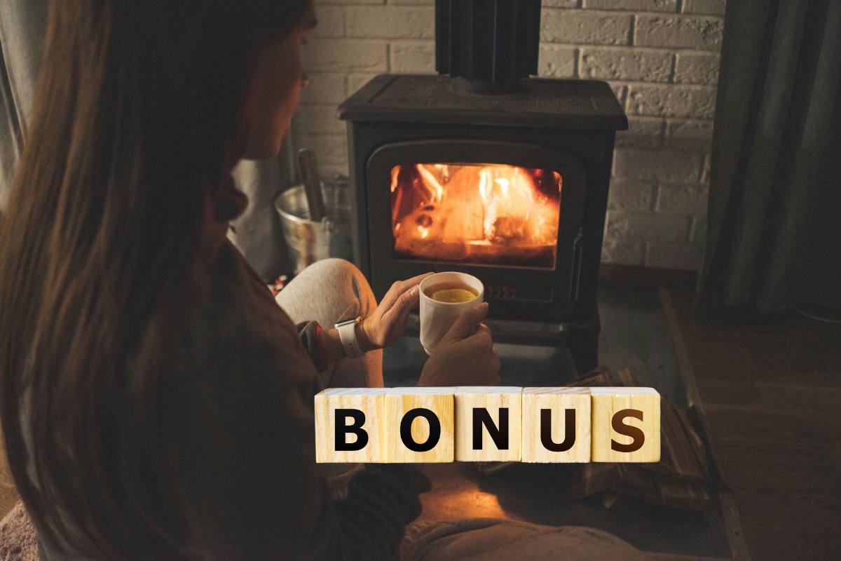 donna con tazza in mano di fronte al camino e scritta bonus