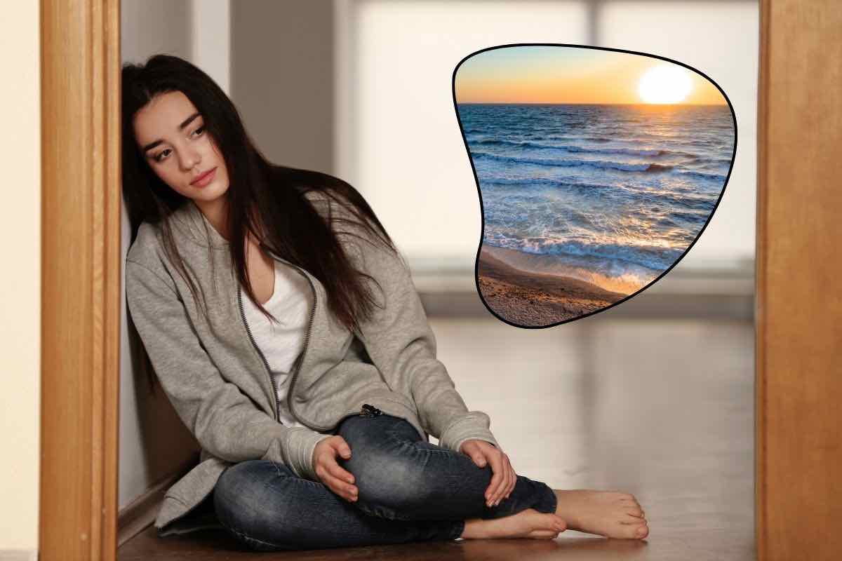 Donna seduta a terra e veduta mare