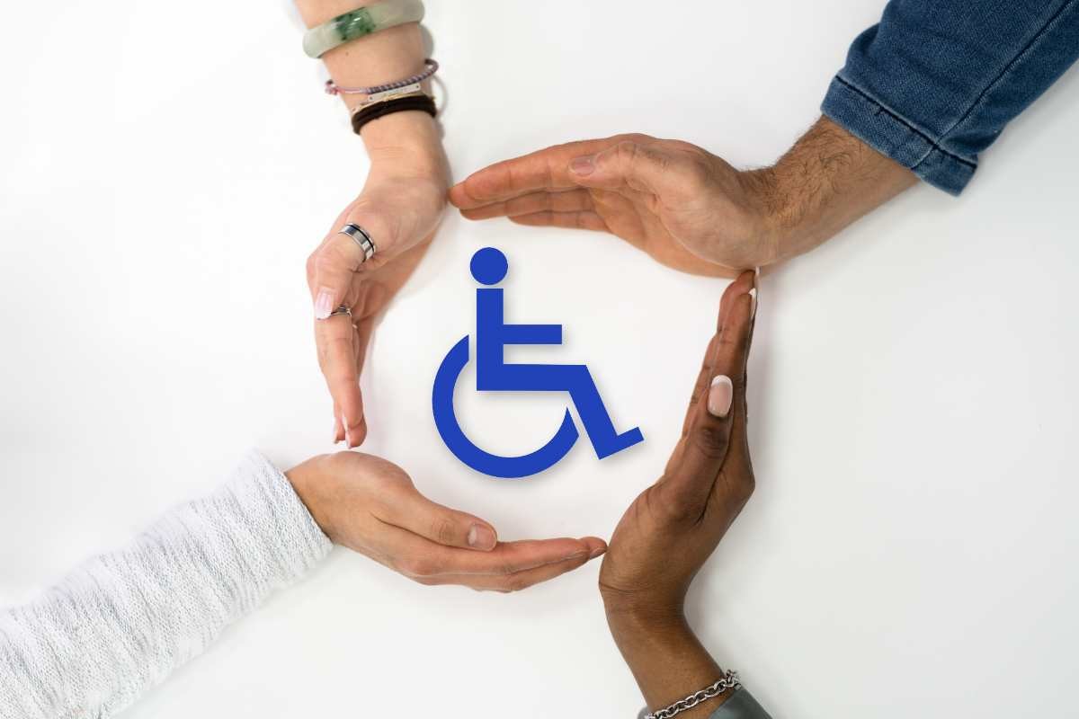 Mani attorno al simbolo della disabilità