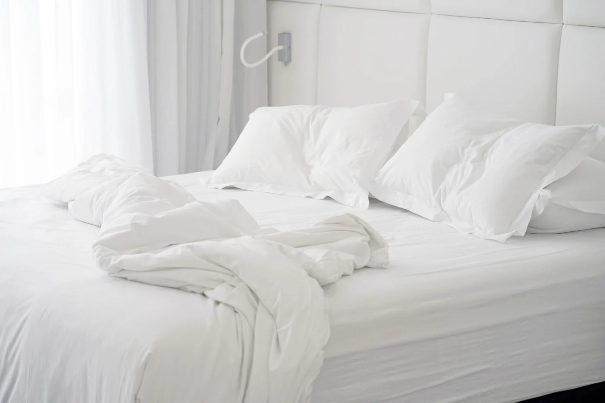 Letto con coperte e lenzuoli bianchi