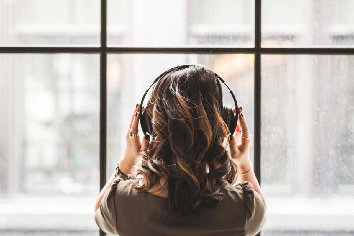 Donna di spalle con cuffie alle orecchie