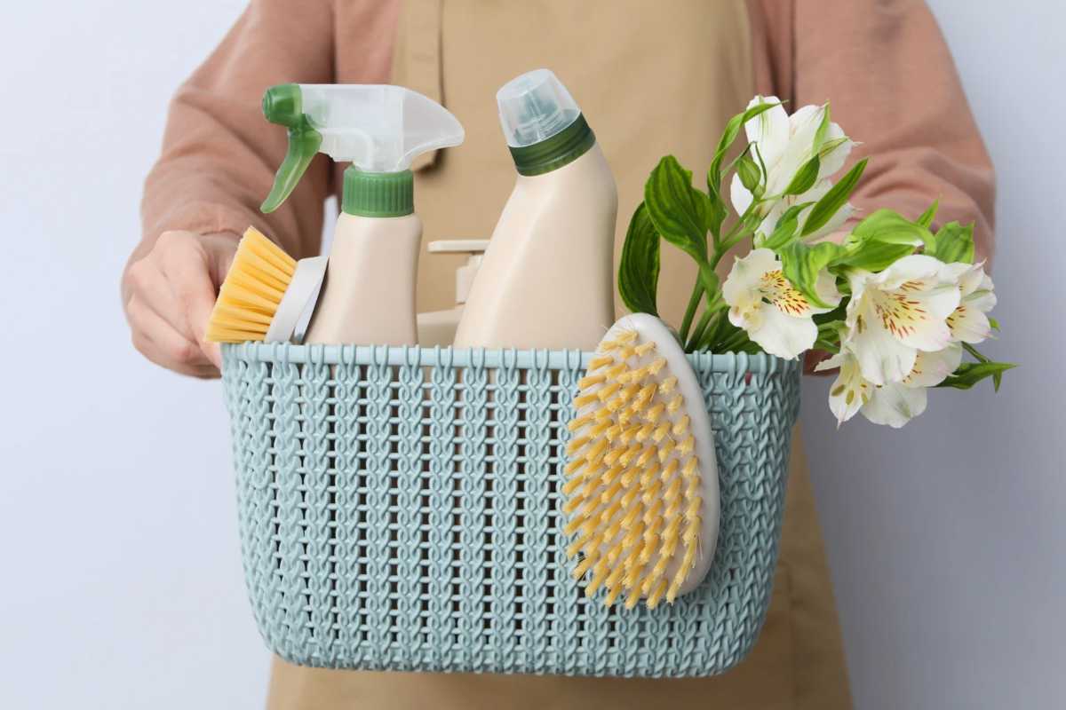 Persona con cestino con prodotti per pulire
