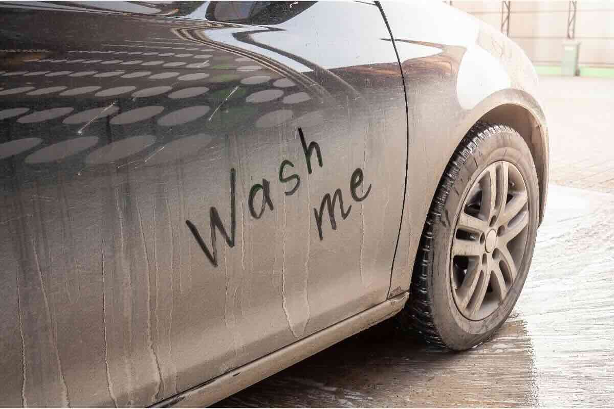 Auto sporca con scritta "wash me"